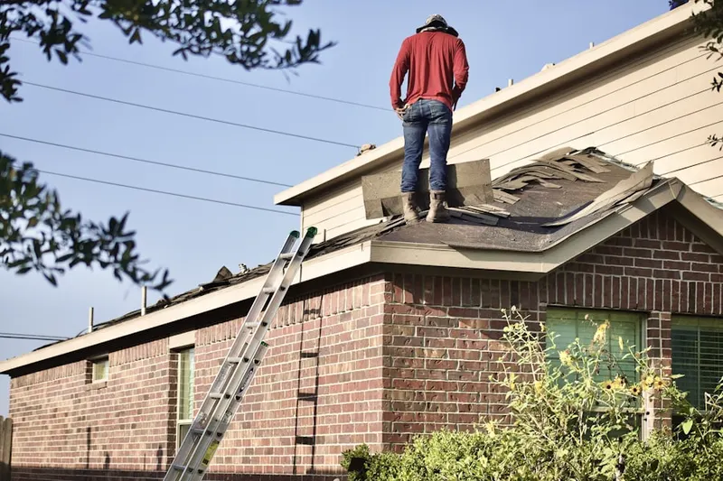 Professional roofer working on a residential roof in Harveston